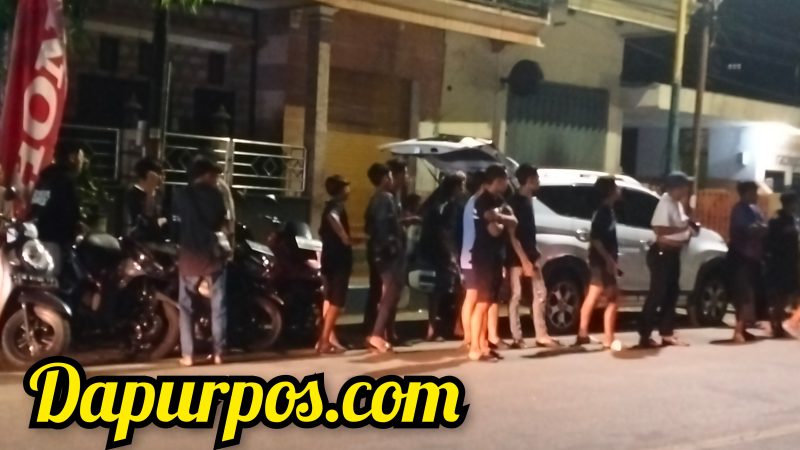 Foto : Nampak anak anak muda yang menonton aksi balap motor liar di pinggir jalan Diponegoro.